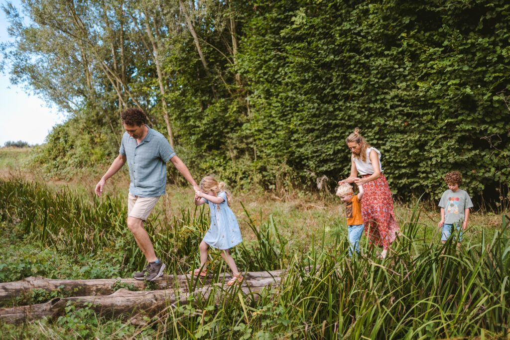Gezin amen op avontuur door het bos tijdens familieshoot